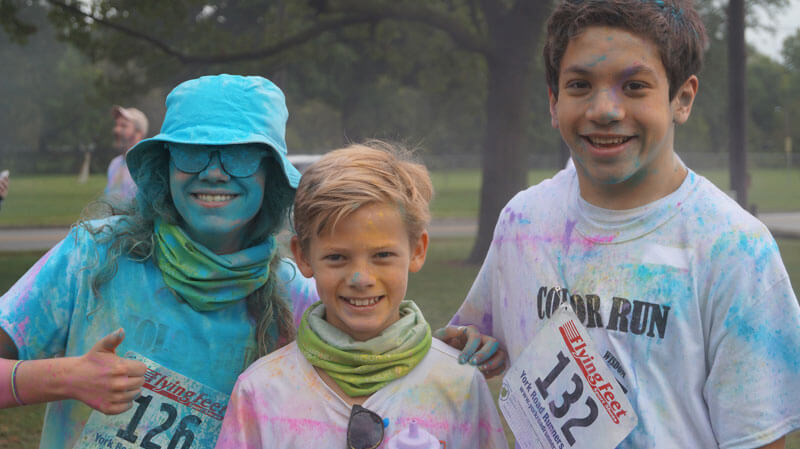 3 students covered in colored chalk