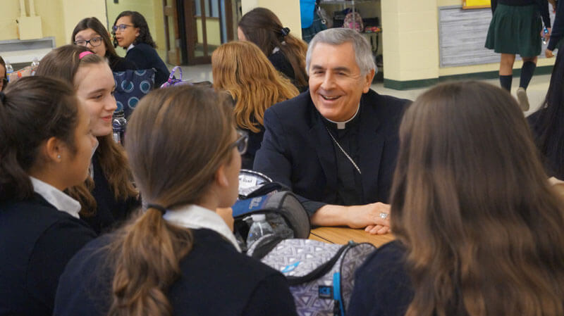bishop talking with students