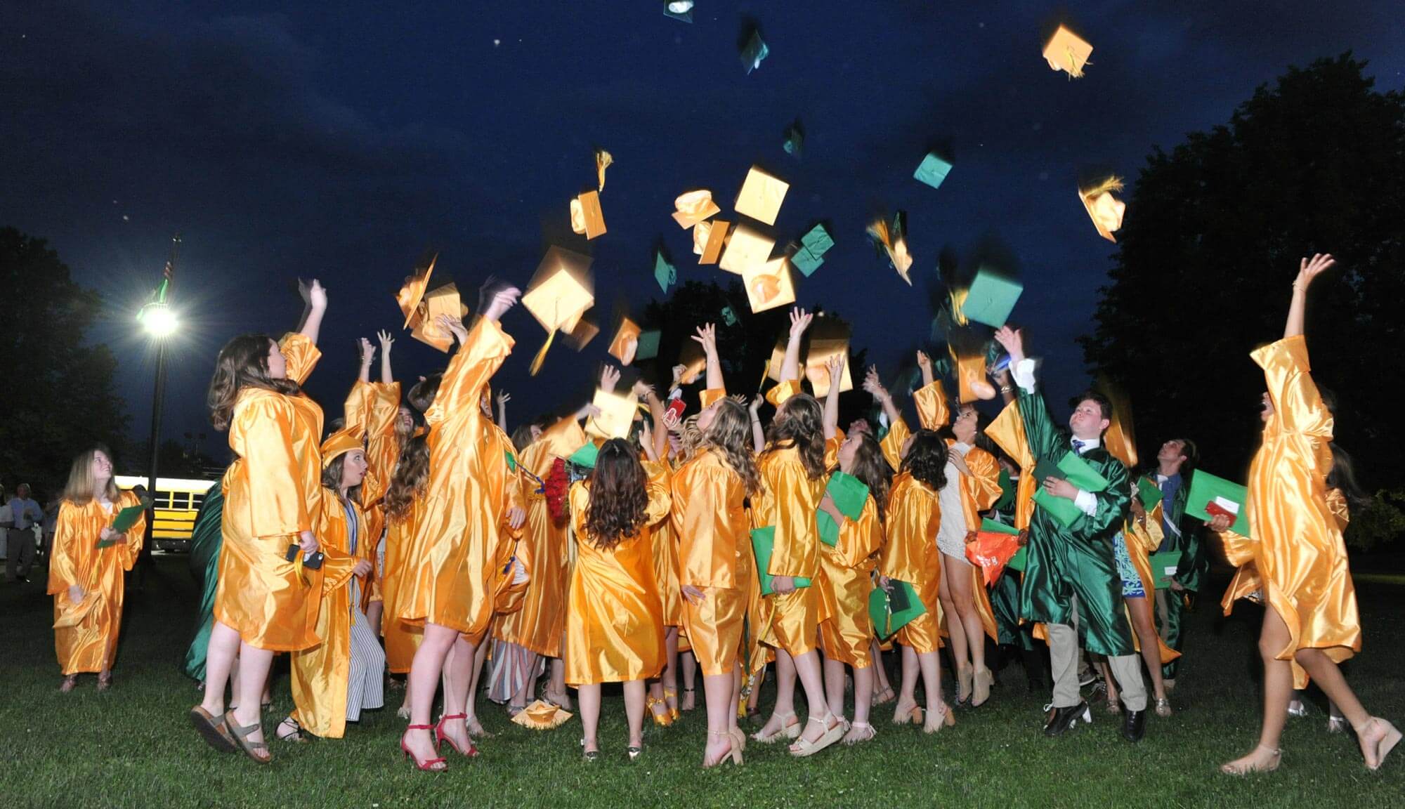 students tossing their caps at graduation
