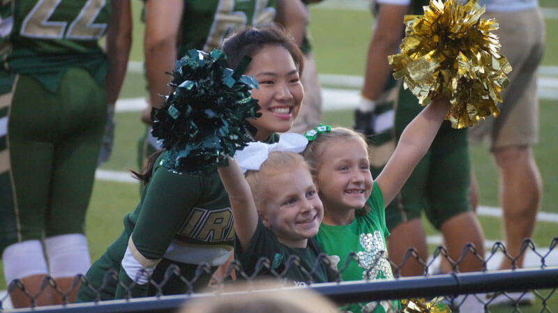 cheerleader with 2 young girls