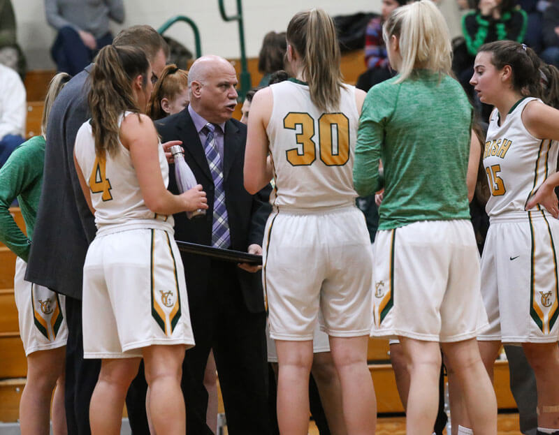 coach in huddle with girls basketball team