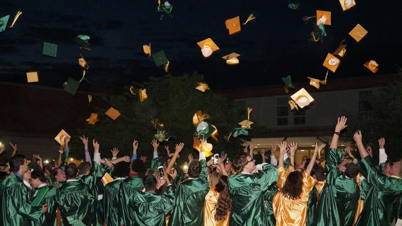 graduation cap toss showing students