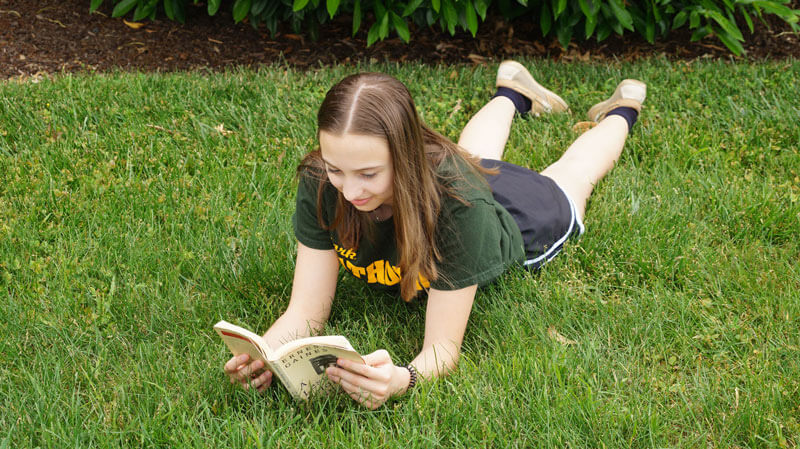 summer reading lying in grass