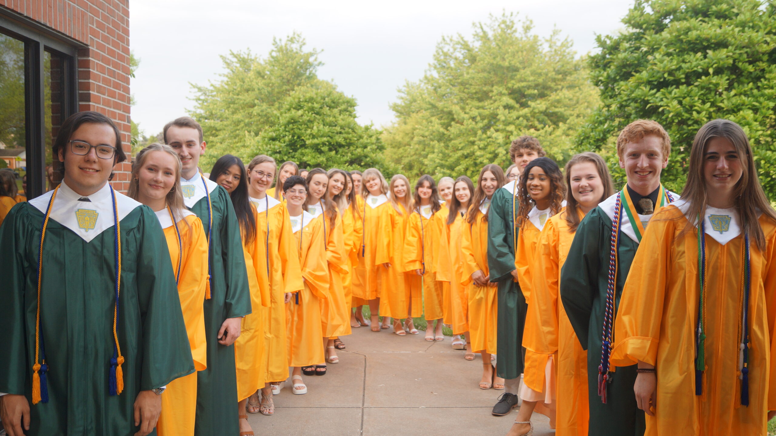 students-in-green-and-gold-caps-and-gowns