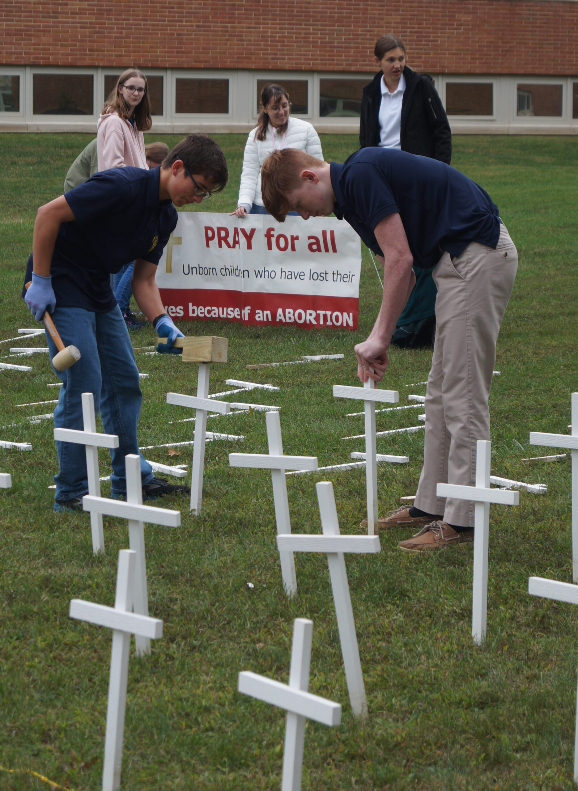 students-installing-crosses-on-lawn