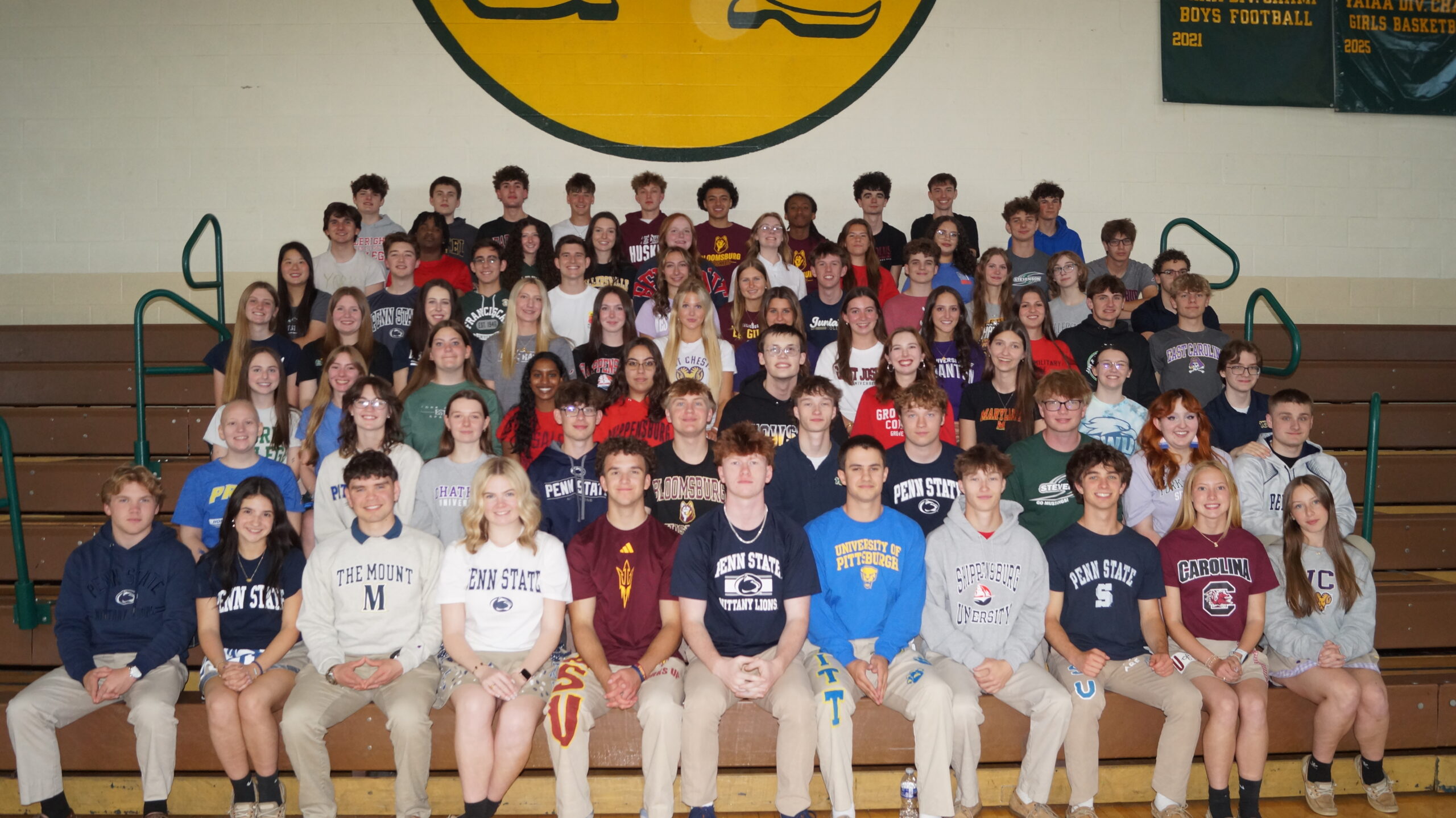 large group of students wearing college t-shirts