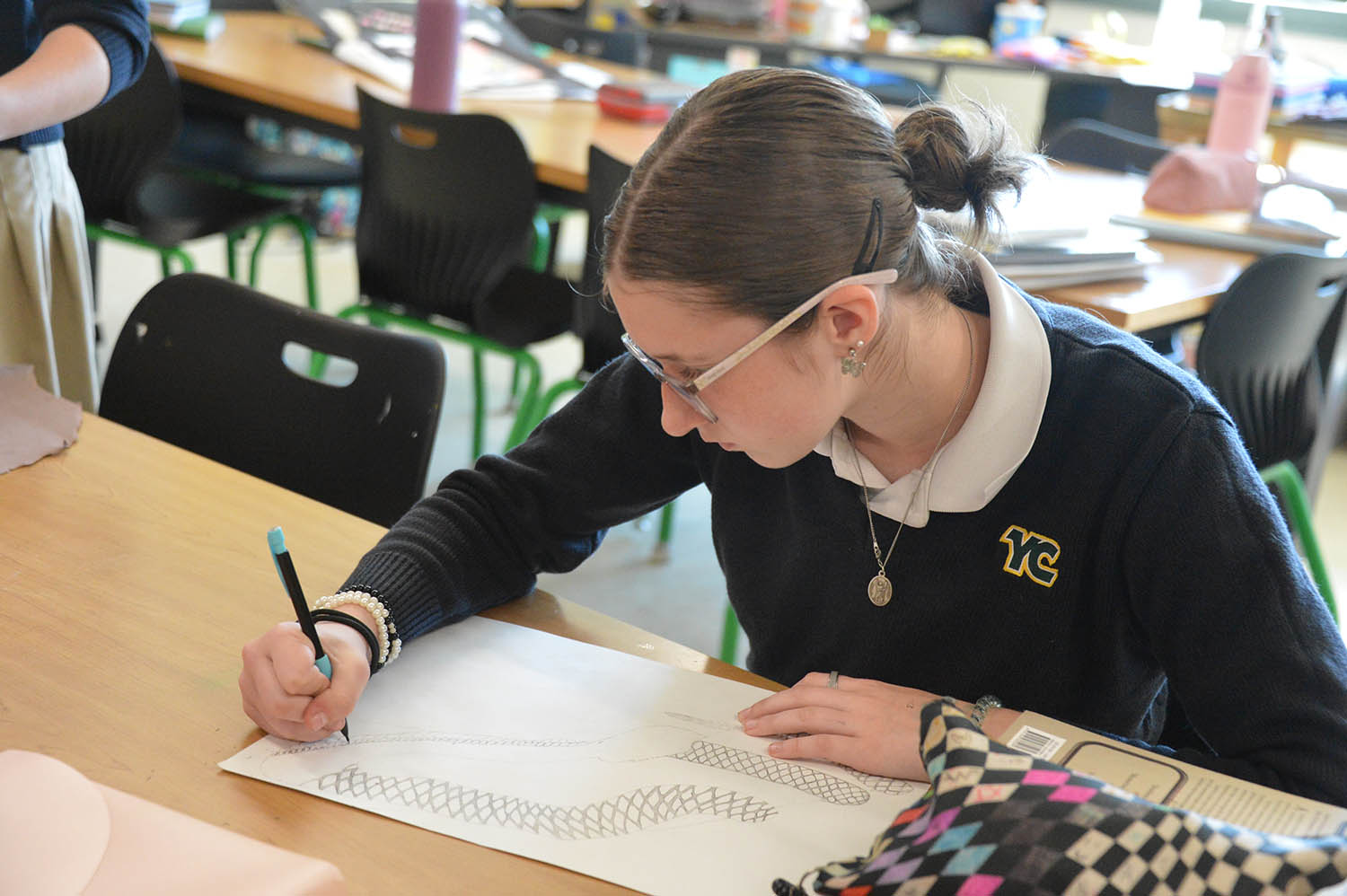 yc student sitting at desk working on art project