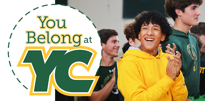 teenage boy smiling during pep rally with 'You Belong at YC' logo