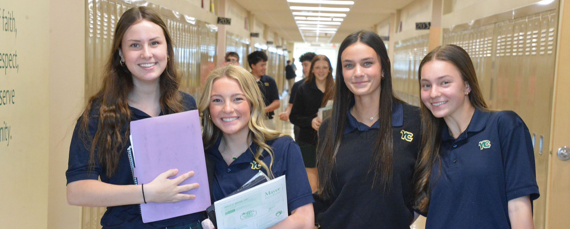 group of teenage YC students smiling in hallway